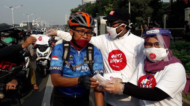 Wakil Ketua KPK Lili Pintauli Siregar membagi-bagikan masker ke pengendara yang melintas di Jalan Sudirman, Jakarta Pusat, Jumat (26/6/2020).