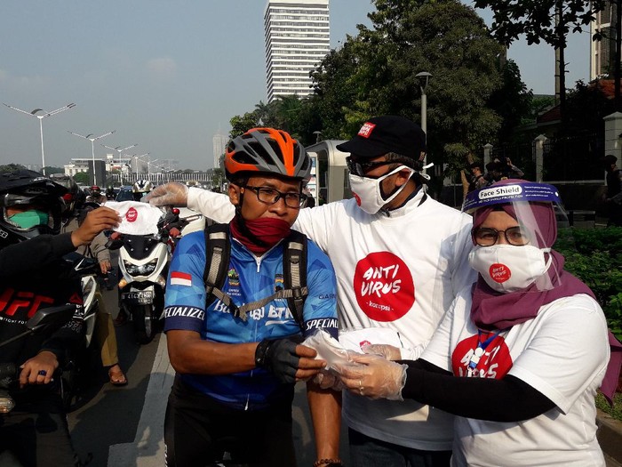 Wakil Ketua KPK Lili Pintauli Siregar membagi-bagikan masker ke pengendara yang melintas di Jalan Sudirman, Jakarta Pusat, Jumat (26/6/2020).