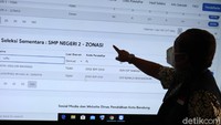 Yana melihat data siswa yang mendaftar ke SMPN 2 Bandung di layar besar.