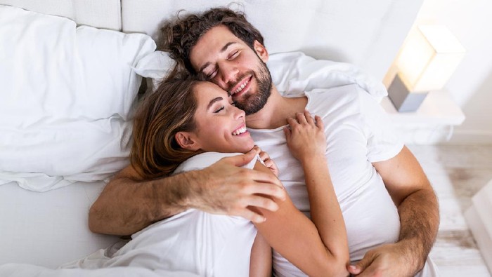 1197800301 Beautiful loving couple kissing in bed. beautiful young couple lying together on the bed. Romantic young couple in love lying on bed. Beautiful couple smiling in bed.