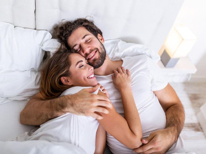 1028900504 Happy millennial couple laughing reading good positive funny information in paper bills or letters, young smiling man and woman having fun with documents and laptop while planning budget finances