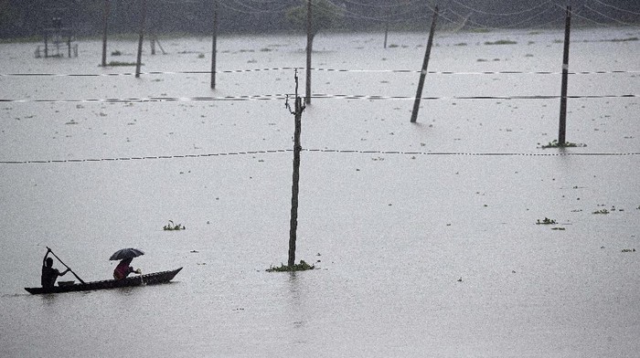 Villagers row country boats through floodwaters in Morigaon district of Assam, India, Friday, June 26, 2020. Following incessant rainfall, the Brahmaputra river and its tributaries continued to rise flooding several districts in the state. (AP Photo/Anupam Nath)