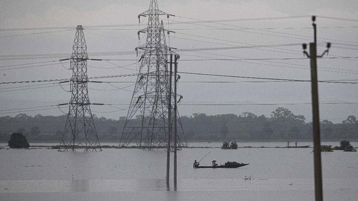 Villagers row country boats through floodwaters in Morigaon district of Assam, India, Friday, June 26, 2020. Following incessant rainfall, the Brahmaputra river and its tributaries continued to rise flooding several districts in the state. (AP Photo/Anupam Nath)