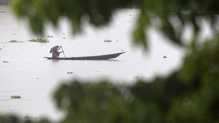 Villagers row country boats through floodwaters in Morigaon district of Assam, India, Friday, June 26, 2020. Following incessant rainfall, the Brahmaputra river and its tributaries continued to rise flooding several districts in the state. (AP Photo/Anupam Nath)