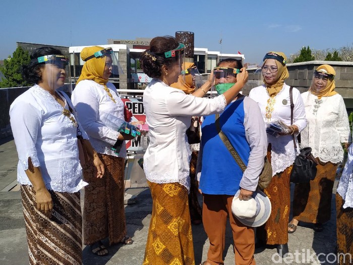 Beberapa perempuan berkebaya membagikan face shield dan masker kepada para pedagang di Makam Bung Karno (MBK). Kegiatan ini mengusung pesan kepedulian perempuan pada kesehatan sesama di tengah pandemi Corona.