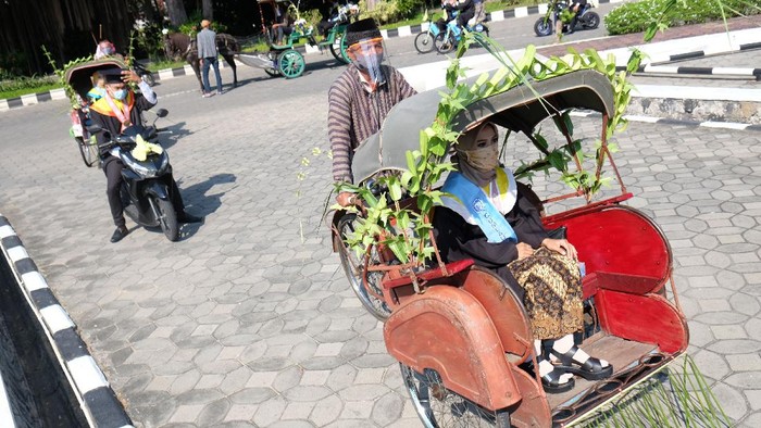 Perwakilan wisudawan Universitas Sebelas Maret (UNS) mengendarai transportasi ramah lingkungan saat mengikuti prosesi acara Wisuda Luring dan Daring secara Drive Thru di kampus setempat, Solo, Jawa Tengah, Sabtu (27/6/2020). Wisuda dengan konsep drive thru tersebut digelar UNS sebagai bentuk kreatifitas adaptasi kampus setempat dalam situasi normal baru ditengah Pandemi COVID-19. ANTARA FOTO/Maulana Surya/hp.