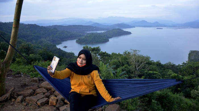 Selfie Yuk di Bukit Indah Beroanging Pengunjung menikmati suasana alam Bukit Bollangi di Desa Timbuseng, Kabupaten Gowa, Sulawesi Selatan, Kamis (11/6/2020). Bukit Bollangi menjadi salah satu destinasi wisata alam yang dikelola oleh warga setempat yang menawarkan keindahan danau, pulau, pegunungan dan sejumlah lokasi untuk berfoto. ANTARA FOTO/Abriawan Abhe/aww.