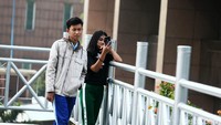 Warga tampak antusias mengabadikan momen dengan latar belakang gedung pencakar langit. 