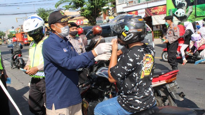 Upaya menekan penyebaran COVID-19 terus dilakukan di Kabupaten Madiun. Polres Madiun telah menggelar patroli tangguh dengan membagikan masker siang malam.