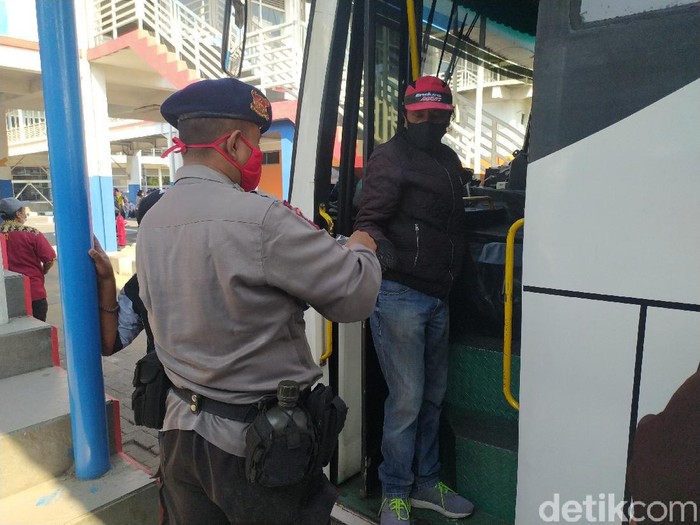 Polisi membagikan masker gratis kepada calon penumpang di Terminal Purabaya, Bungurasih, Sidoarjo. Pembagian masker itu untuk menekan penyebaran virus Corona di Jatim.