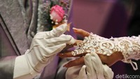 Pengantin saling memasangkan cincin pernikahan.