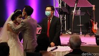 Pengantin harus memakai masker dalam pernikahan tersebut. Marker pun tetap dipakai saat mencium pasangannya.