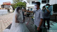 Pengantin harus menjalani pengecekan suhu tubuh sebelum memasuki gereja.