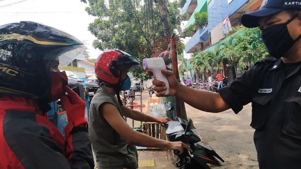 Pemeriksaan suhu tubuh untuk pembeli yang datang ke Pasar Palmerah.
