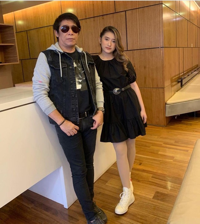Inilah penampilan feminin Amanda Caesa yang berpose dengan sang ayah. Gadis 17 tahun itu menggunakan dress hitam dan ikat pinggang.  Foto: Instagram amandacaesaa