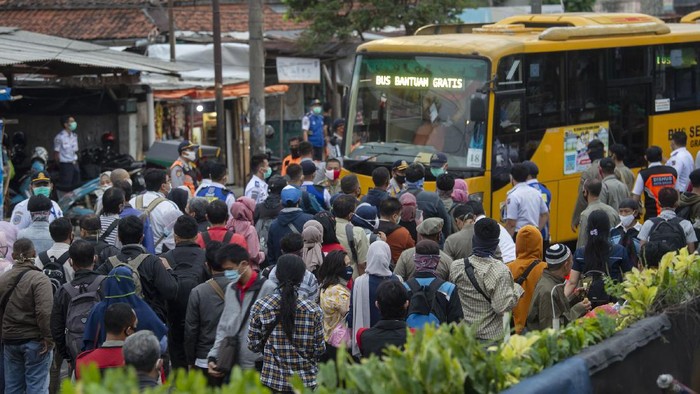 Sejumlah warga mengantre masuk ke dalam bus yang disediakan pemerintah untuk antisipasi membludaknya calon pemnumpang Kereta Rel Listrik (KRL) Commuterline di Stasiun KA Kota Bogor, Jawa Barat, Senin (29/6/2020). Pembatasan penumpang di dalam KRL maupun di area peron menyebabkan antrean panjang penumpang di stasiun tersebut. Untuk mengurainya, pemerintah menyediakan bus gratis dan PT Kereta Commuter Indonesia mengujicobakan sistem informasi mengenai antrean melalui laman utama di aplikasi KRL Acccess dan media sosialnya. ANTARA FOTO/Aditya Pradana Putra/wsj.