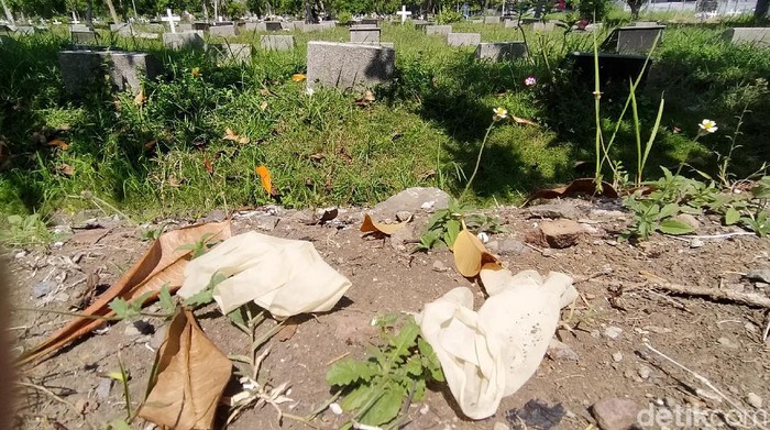 APD tenaga medis bekas penanganan jenazah COVID-19 berserakan di TPU Babat Jerawat, Surabaya. Mulai dari hazmat, sarung tangan dan face shield.