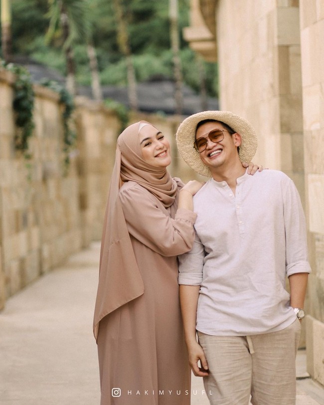 Memakai busana serba pastel mocca, Ciki juga mengaplikasikan makeup peach brown natural flawless yang membuat wajahnya semakin memesona. Menyesuaikan penampilan sang istri, Rezky Aditya mengenakan busana serba putih. Dia bergaya casual memakai topi fedora, kemeja dan celana chino pendek. Foto: instagram @hakimyusufl.