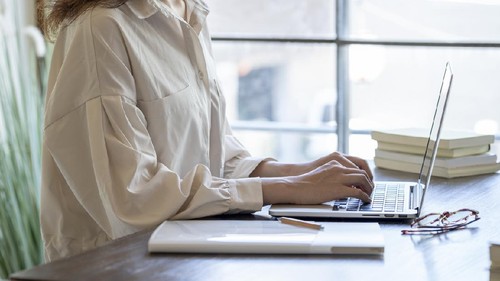 The hand of a young woman working at remote work