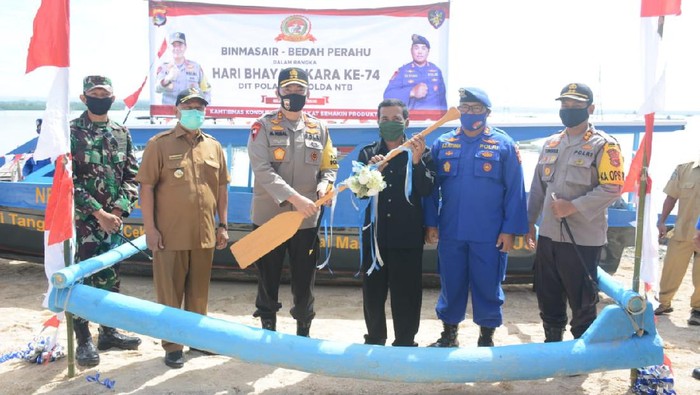 Kapolda NTB Irjen M Iqbal secara simbolis menyerahkan bantuan kapal untuk mempermudah siswa SD di Lombok Timur bersekolah (Dok. istimewa)