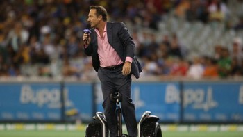 Seorang presenter syuting di tengah lapanagn memakai Segway. Foto: Getty Images