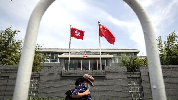 A woman wearing a protective face mask walks by the Government of Hong Kong Special Administrative Region office building in Beijing, Tuesday, June 30, 2020. Hong Kong media are reporting that China has approved a contentious law that would allow authorities to crack down on subversive and secessionist activity in Hong Kong, sparking fears that it would be used to curb opposition voices in the semi-autonomous territory. (AP Photo/Andy Wong)