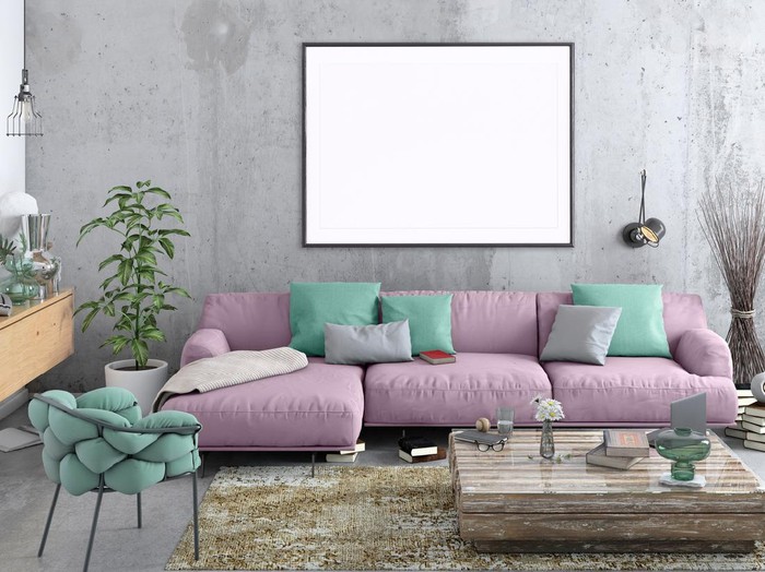 Modern Nordic style apartment interior. Large pastel colored sofa with armchair. Concrete textured wall with picture frame template for copy space. Books, plant and lots of other details. Designer artist background template.