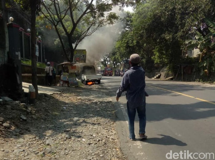 Sebuah mobil pikap terbakar di pinggir jalan Cianjur