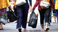 Sejumlah warga tampak membawa kantong plastik saat tengah beraktivitas di kawasan Pasar Jatinegara, Jakarta, Selasa (30/6/2020).