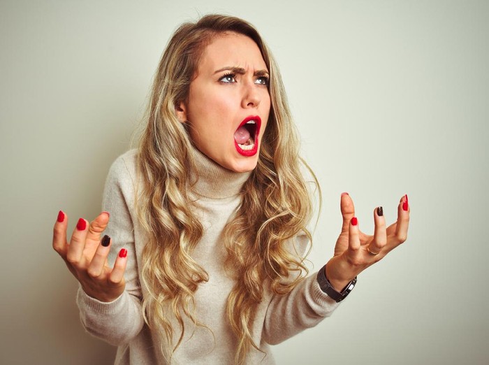 Wanita Marah Beautiful woman wearing winter turtleneck sweater over isolated white background crazy and mad shouting and yelling with aggressive expression and arms raised. Frustration concept.