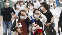 Sejumlah pengunjung pun berdatangan untuk bermain di taman hiburan yang sebelumnya ditutup sejak akhir Februari lalu guna mencegah penyebaran virus Corona. Kyodo News via AP Photo.