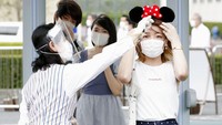 Taman hiburan yang populer di kawasan Tokyo tersebut kembali dibuka untuk umum dengan menerapkan sejumlah protokol kesehatan. Para pengunjung yang hendak masuk area taman hiburan Disneyland Tokyo tampak diukut suhu tubuhnya oleh petugas. Kyodo News via AP Photo.