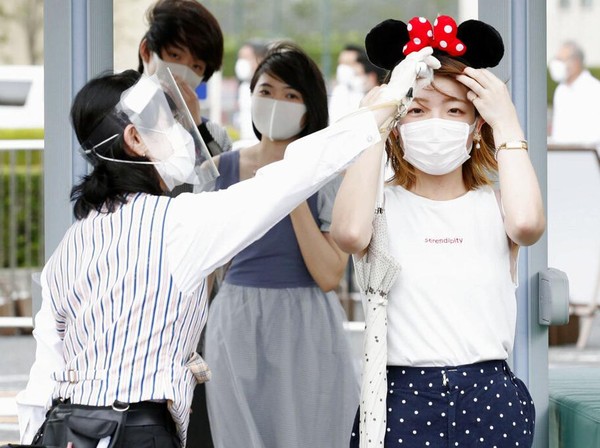 Taman hiburan yang populer di kawasan Tokyo tersebut kembali dibuka untuk umum dengan menerapkan sejumlah protokol kesehatan. Para pengunjung yang hendak masuk area taman hiburan Disneyland Tokyo tampak diukut suhu tubuhnya oleh petugas. Kyodo News via AP Photo. Taman hiburan yang populer di kawasan Tokyo tersebut kembali dibuka untuk umum dengan menerapkan sejumlah protokol kesehatan. Para pengunjung yang hendak masuk area taman hiburan Disneyland Tokyo tampak diukut suhu tubuhnya oleh petugas. Kyodo News via AP Photo.