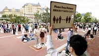 Selain itu, para pengunjung juga diimbau untuk menerapkan physical distancing atau jaga jarak saat beraktivitas di taman hiburan tersebut. Kyodo News via AP Photo.