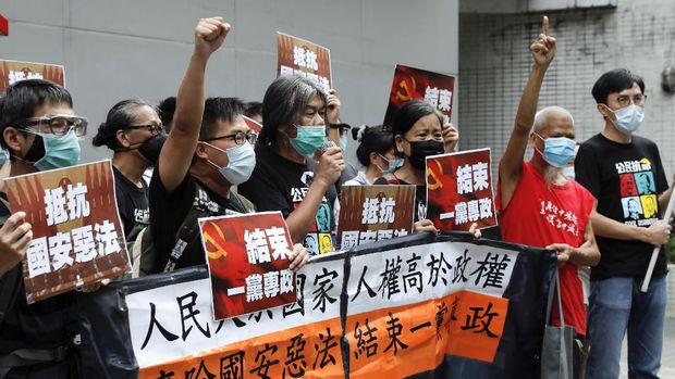 Pro-democracy Leung Kwok-hung, center, and others protesters shout slogans 
