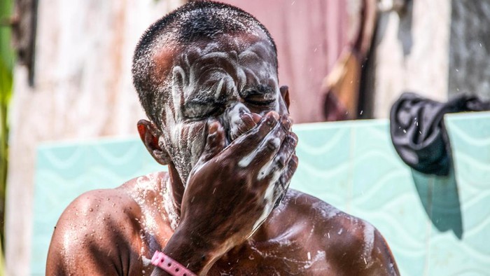 Seorang pengungsi etnis rohingya mandi dengan air yang dipasok mobil tangki bantuan di tempat penampungan bekas gedung imigrasi, Punteuet, Lhokkseumawe, Aceh, Rabu (1/7/2020). Kondisi tempat penampungan 99 orang pengungsi rohingya itu terkedala keterbatasan air bersih terutama untuk kebutuhan MCK, dan bersuci (wudhu). ANTARA FOTO/Rahmad/aww.