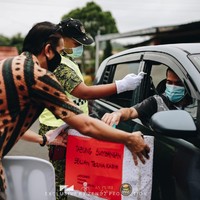 Tamu resepsi pernikahan drive thru memberikan angpau melalui kotak yang sudah disediakan panitia. Pemeriksaan suhu tubuh juga dilakukan di tahapan ini. Foto: Dok. Zenuz Production