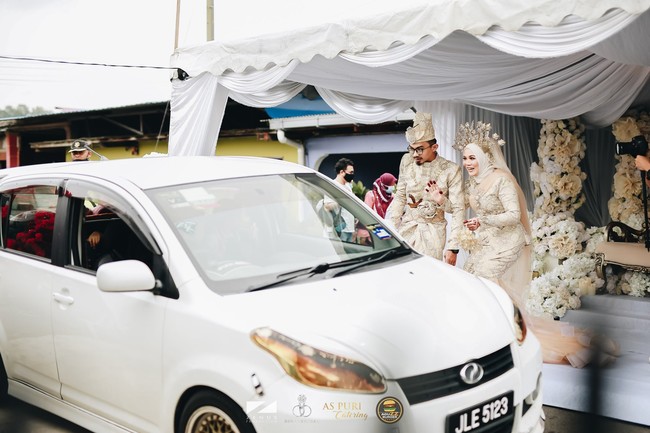 Wawa dan Aguss (pemilik perniagaan Burger Viral AguzzBurger). Merupakan  majlis perkahwinan pertama yang berkonsepkan drive thru di Malaysia.  Mengekalkan SOP mengikut saranan Kementerian Kesihatan Malaysia, demikian yang ditulis Zenuz Production pada keterangan fotonya. Foto: Dok. Zenuz Production