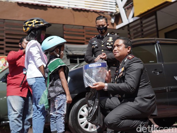 Kakak beradik di Kota Probolinggo bersepeda menuju mapolres. Mereka memberi kado face shield dan masker ke polisi di HUT ke-74 Bhayangkara.