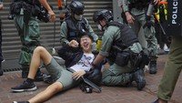 Polisi menggunakan senjata tembakan merica dan meriam air untuk membubarkan para demonstran. Polisi juga mengatakan satu petugas telah terluka karena ulah pengunjuk rasa dan yang lain telah membakar barikade sembari menghalangi lalu lintas. AP Photo/Vincent Yu.