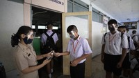 Sebelum memasuki kelas, setiap siswa juga harus diberikan hand sanitizer untuk mencegah penyebaran Corona. AP Photo/Sakchai Lalit  