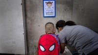 Seorang guru membimbing siswa tentang cara mencuci tangan di pintu masuk prasekolah Makkasan di Bangkok, Thailand. AP Photo/ Gemunu Amarasinghe  