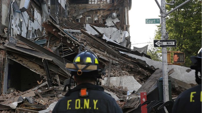 A firefighter watches as a FDNY Special Operations Command vehicle clears rubble after a multistory building that housed a health club collapsed, Wednesday, July 1, 2020, in the Carroll Gardens neighborhood of the Brooklyn borough of New York. The building had been shuttered during the coronavirus pandemic. Only three weeks ago, building inspectors ordered a halt to some construction work at the location because of structural problems. (AP Photo/Kathy Willens)