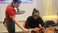Saat ini karyawan restoran dilengkapi dengan face shield, masker, dan sarung tangan ketika menyajikan makanan dan minuman untuk tamu. (Foto: Putu Intan/detikcom)