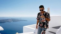 Masih di Santorini, Indra sengaja pilih outfit kasual. Ia melengkapi momen santainya dengan menyedot minuman segar. Foto: Instagram indpriw