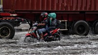 Meski tergenang, tak sedikit kendaraan yang tetap melintasi jalan yang menuju ke arah Pelabuhan Tanjung Priok tersebut.