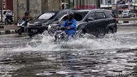 Sejumlah kendaraan melintasi Jalan Yos Sudarso yang tergenang usai hujan mengguyur wilayah Jakarta, siang tadi, Kamis (2/7/2020).