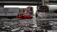 Sejumlah kendaraan roda empat melintasi Jalan Yos Sudarso yang tergenang di kawasan Jakarta Utara, Kamis (2/7/2020).