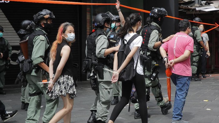 Police detain protesters after a protest in Causeway Bay before the annual handover march in Hong Kong, Wednesday, July. 1, 2020. Hong Kong marked the 23rd anniversary of its handover to China in 1997, and just one day after China enacted a national security law that cracks down on protests in the territory. Hong Kong police said on Facebook they had arrested over 30 people on various charges, from unlawful assembly to the violation of a national security law on the first day of the law. (AP Photo/Kin Cheung)