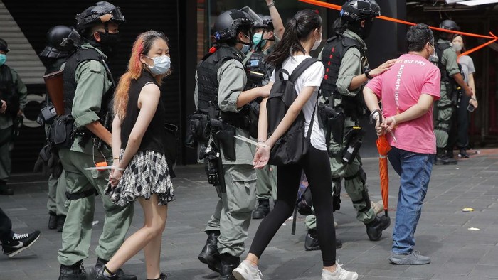 Police detain protesters after a protest in Causeway Bay before the annual handover march in Hong Kong, Wednesday, July. 1, 2020. Hong Kong marked the 23rd anniversary of its handover to China in 1997, and just one day after China enacted a national security law that cracks down on protests in the territory. Hong Kong police said on Facebook they had arrested over 30 people on various charges, from unlawful assembly to the violation of a national security law on the first day of the law. (AP Photo/Kin Cheung)